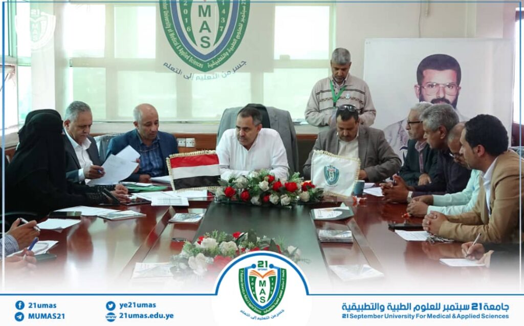 Delegates sit around a conference table in a formal meeting at 21 September University of Medical and Applied Sciences, MAS logo visible in background.