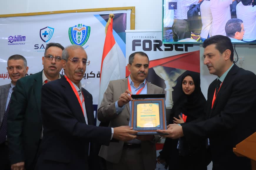 Group of men in business attire presenting a framed award to a colleague at a conference or ceremony.