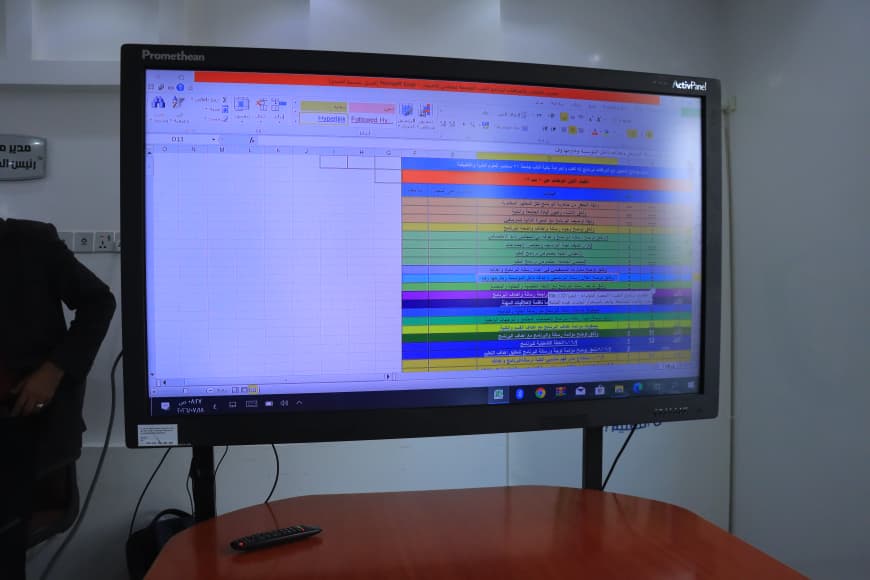 Colorful, color-coded timetable shown on a Promethean interactive whiteboard in a conference room