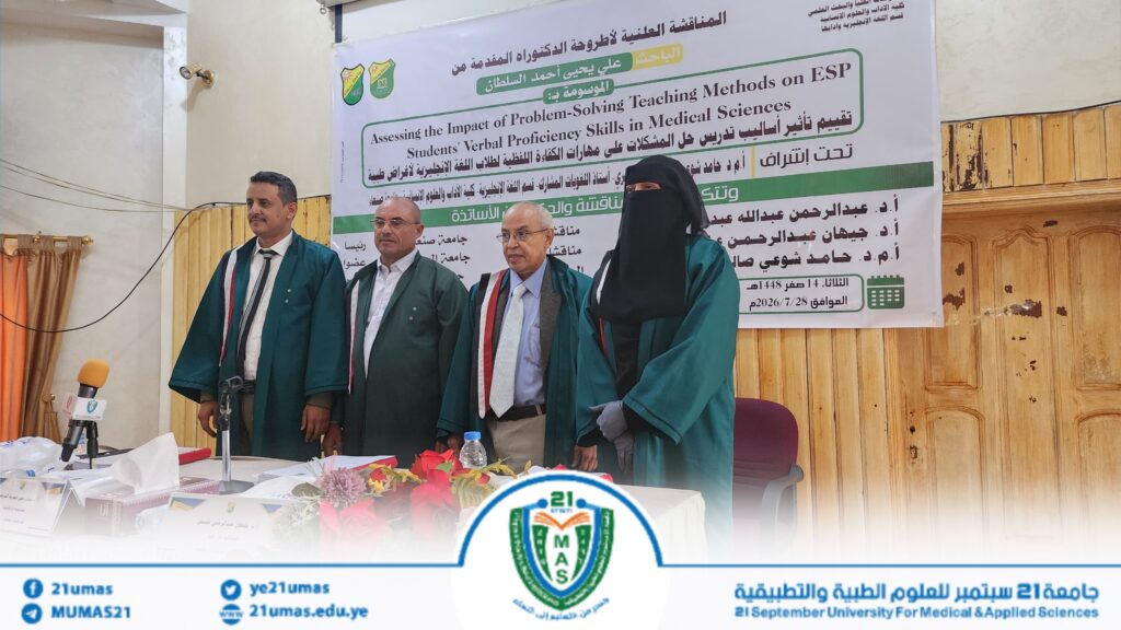 1004053935 - جامعة 21 سبتمبر Four speakers in green academic robes stand on a stage in front of a large banner for a university conference on problem-solving teaching methods in medical sciences, with microphones and a floral arrangement nearby.