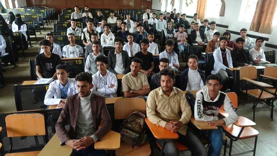 A large classroom full of students seated in rows, facing forward during a lecture.