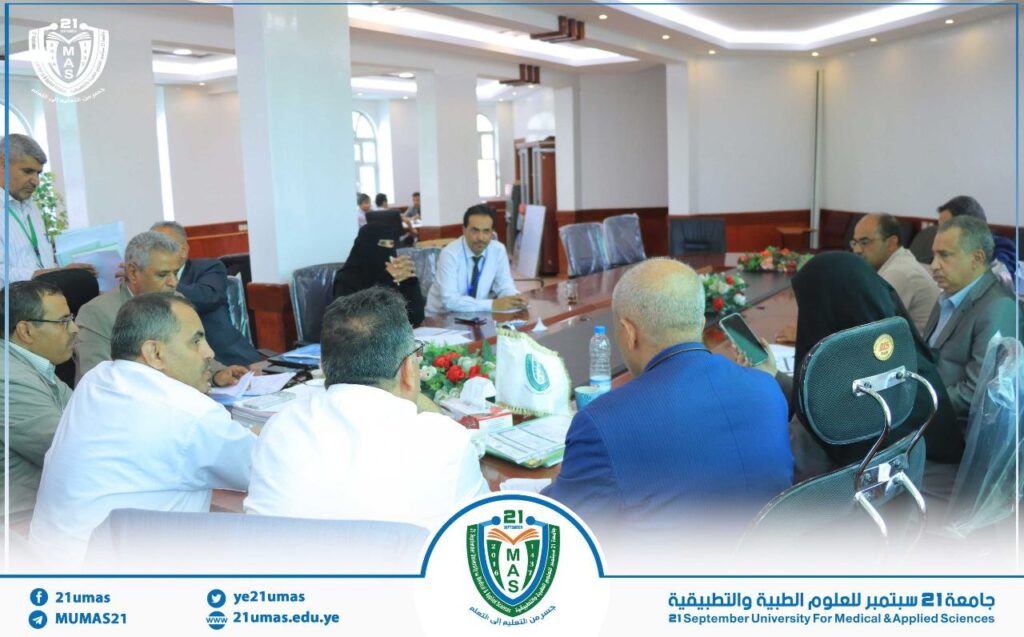 Group of professionals seated around a long conference table in a bright meeting room, reviewing documents.