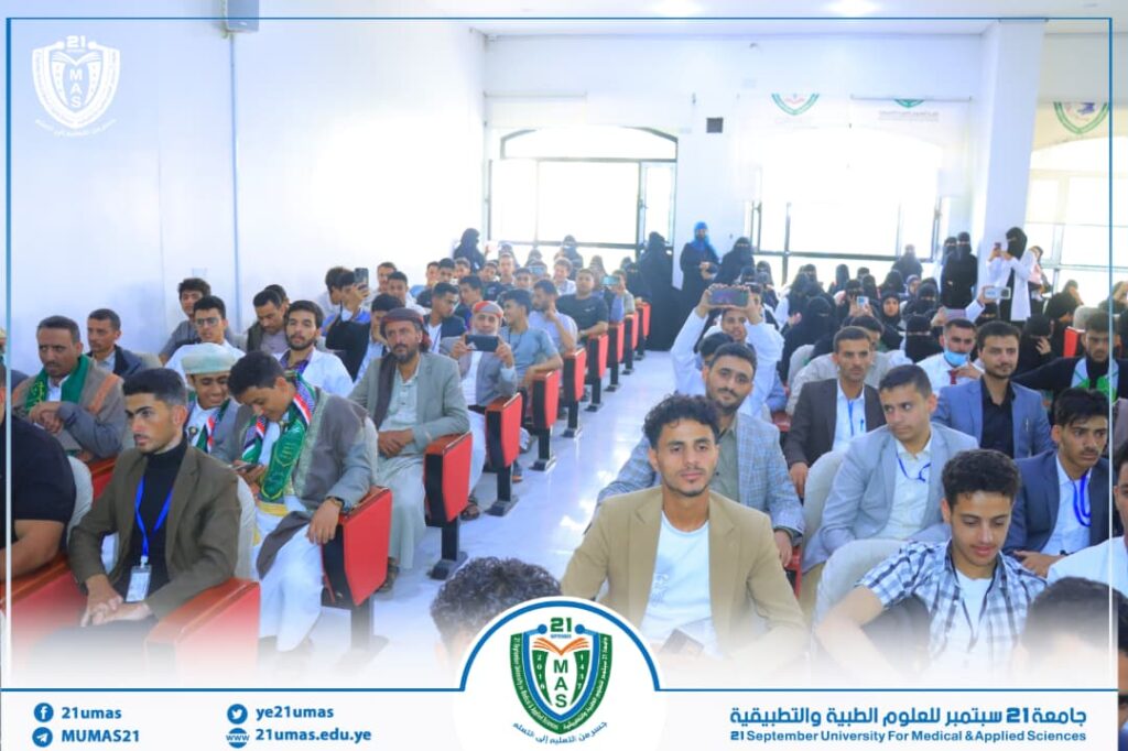 Large group of students seated in an auditorium for a university event, with the El September University banner and logo at the front.