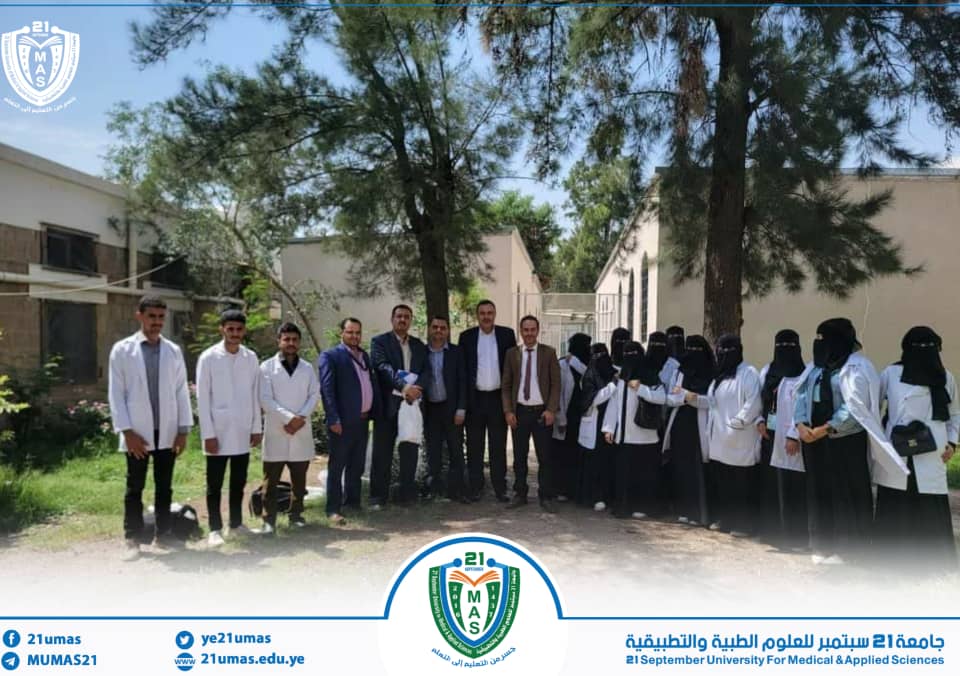 Group of students and staff posing outdoors in front of a campus building, with university crest and a blue banner at the bottom. (Medical and Applied Sciences program)