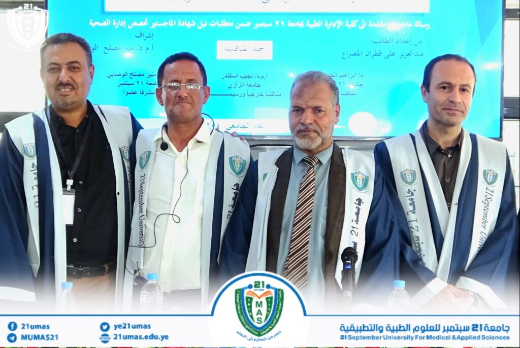 Four men in blue and white graduation robes posing at a university event, with a blue banner behind them.