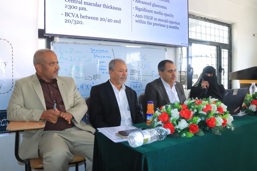 Panel of four experts seated at a table with a floral centerpiece during a conference discussion, with slides projected behind them.