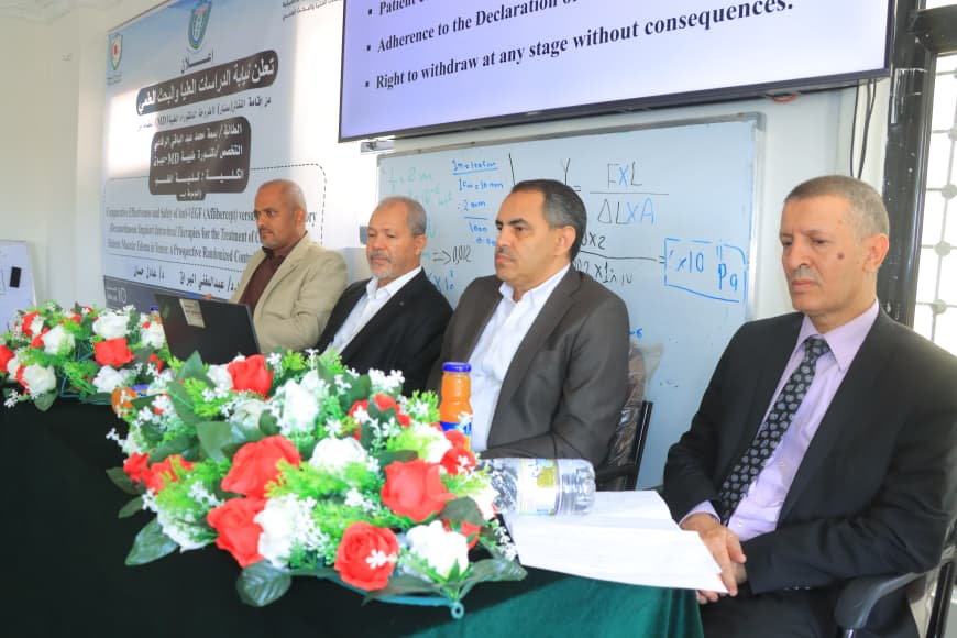 Panel of four men in suits seated at a conference table with a floral centerpiece; a whiteboard with equations and a slide showing bullet points behind them.